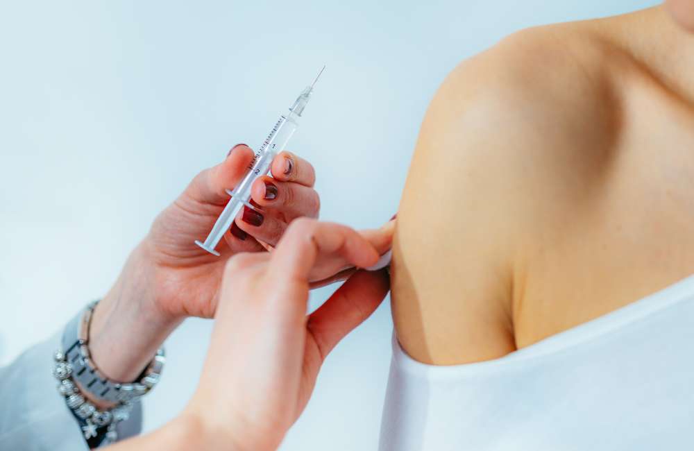 A doctor about to inject a needle next to a person's arm
